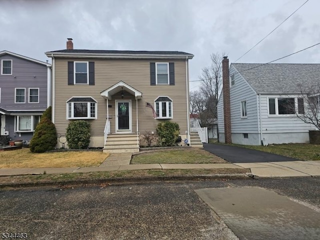 view of front of home featuring aphalt driveway and a chimney