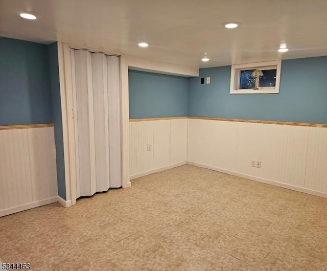 finished basement with tile patterned floors, recessed lighting, and wainscoting