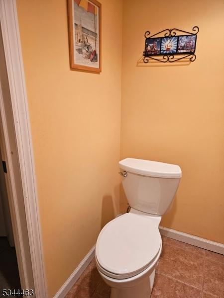 bathroom with tile patterned floors, toilet, and baseboards