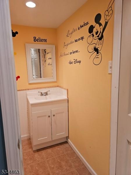 bathroom featuring tile patterned floors, baseboards, and vanity