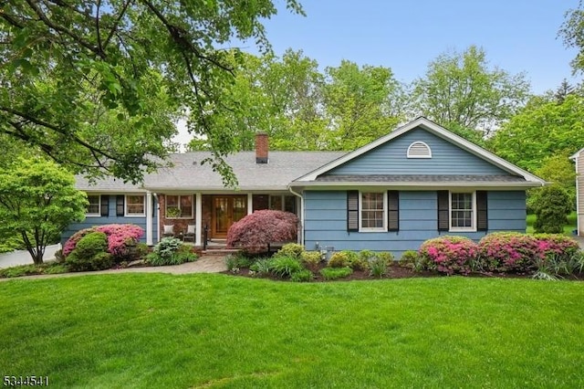 ranch-style home featuring a chimney and a front lawn