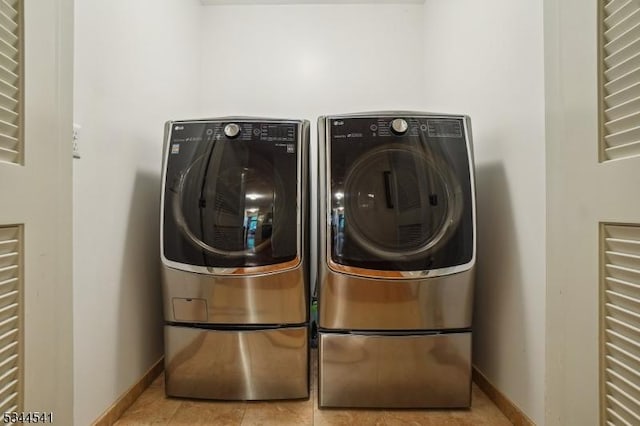 laundry room with independent washer and dryer, baseboards, and tile patterned floors