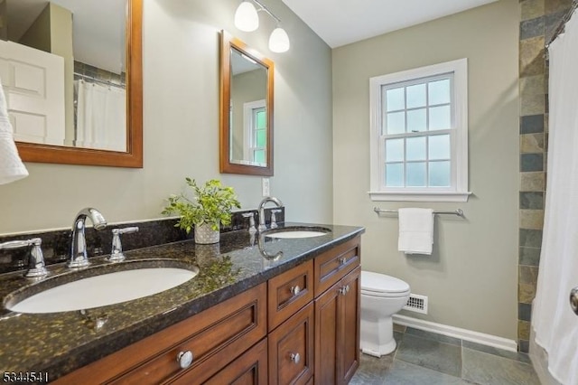 bathroom featuring baseboards, toilet, double vanity, and a shower with curtain