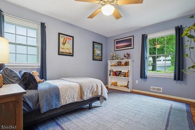 bedroom with wood finished floors, baseboards, and a ceiling fan