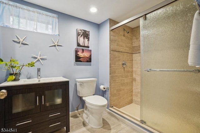 full bathroom featuring a shower stall, toilet, vanity, baseboards, and tile patterned flooring