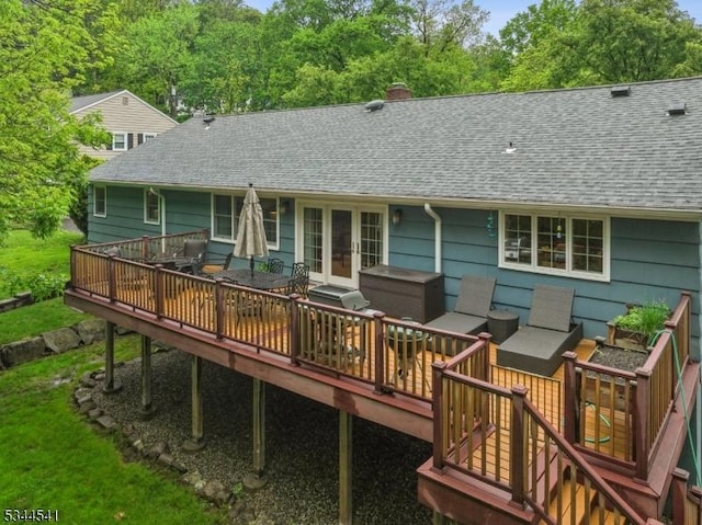 back of property featuring a deck, a shingled roof, french doors, and a chimney