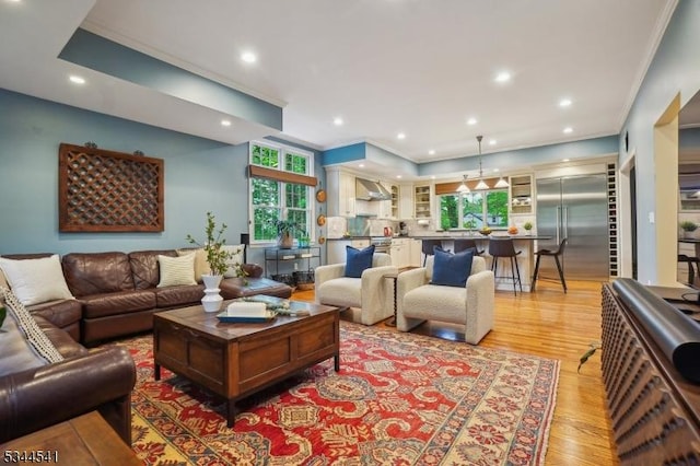 living area featuring crown molding, light wood-style floors, and recessed lighting