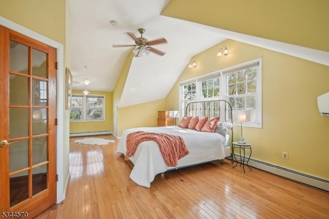 bedroom with wood-type flooring, vaulted ceiling, baseboard heating, and multiple windows