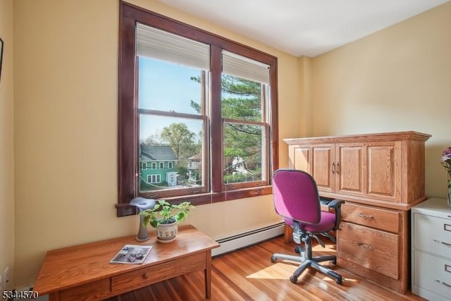 home office featuring a baseboard radiator and wood finished floors