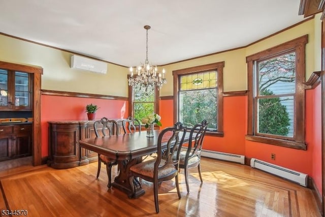 dining area with wood finished floors, ornamental molding, a wall unit AC, and a notable chandelier
