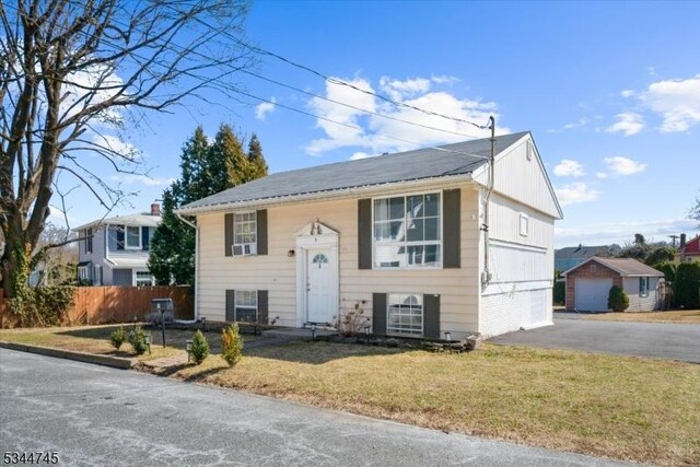 split foyer home featuring a front lawn, fence, and driveway