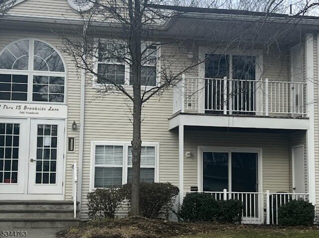 back of property with french doors and a balcony