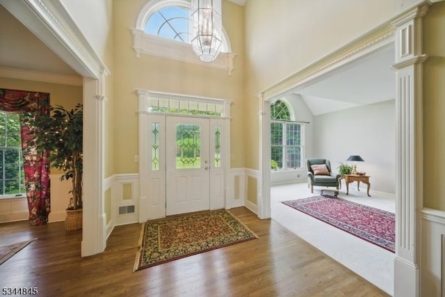 2 Wakefield Dr, Washington Twp, NJ 07840 - foyer featuring a chandelier, a wainscoted wall, wood finished floors, a decorative wall, and ornate columns