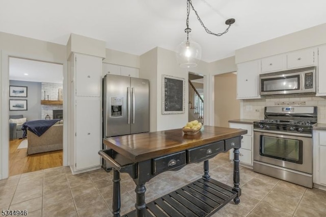 2 Columbia Dr, Bernardsville Boro, NJ 07924 - kitchen featuring appliances with stainless steel finishes, white cabinetry, tasteful backsplash, hanging light fixtures, and light tile patterned floors
