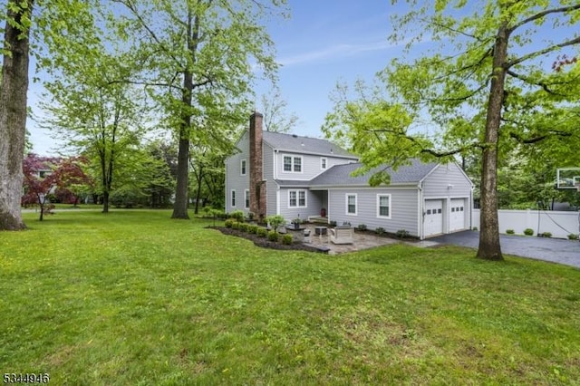 2 Columbia Dr, Bernardsville Boro, NJ 07924 - back of house featuring asphalt driveway, a garage, a chimney, and a patio area