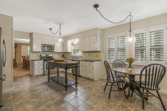 2 Columbia Dr, Bernardsville Boro, NJ 07924 - kitchen with appliances with stainless steel finishes, tasteful backsplash, decorative light fixtures, white cabinetry, and baseboards