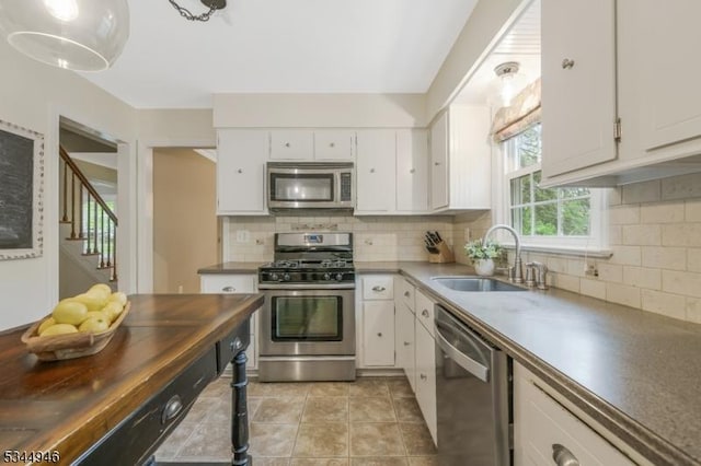 2 Columbia Dr, Bernardsville Boro, NJ 07924 - kitchen with stainless steel appliances, a sink, white cabinetry, and tasteful backsplash