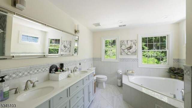 1121 N Washington Ave, Green Brook Twp, NJ 08812 - bathroom featuring a garden tub, toilet, wainscoting, double vanity, and marble finish floors