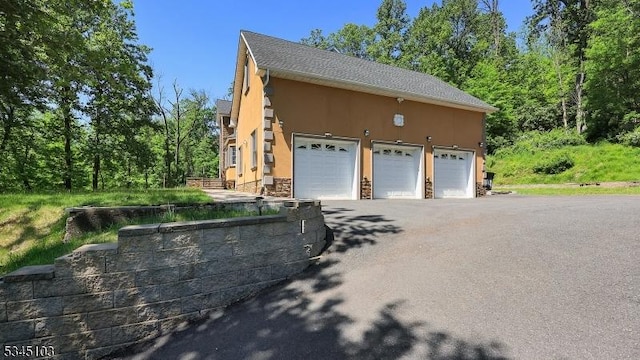 1121 N Washington Ave, Green Brook Twp, NJ 08812 - view of home's exterior featuring stucco siding, a garage, and stone siding