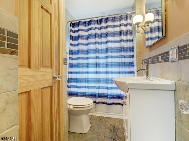 bathroom with tile walls, vanity, curtained shower, and toilet