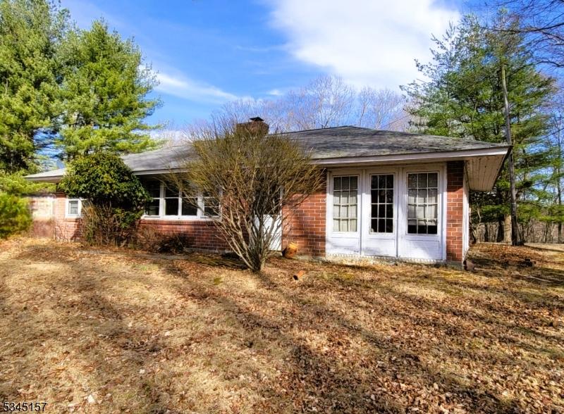 rear view of property featuring brick siding and a chimney