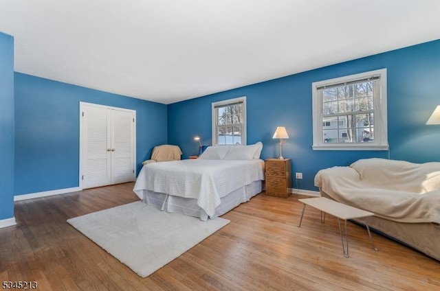 bedroom featuring baseboards, a closet, and wood finished floors
