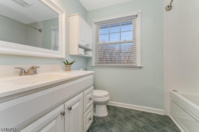bathroom featuring toilet, vanity, baseboards, and shower / tub combination