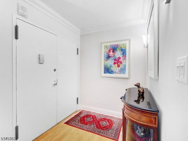 entryway featuring ornamental molding, baseboards, and wood finished floors