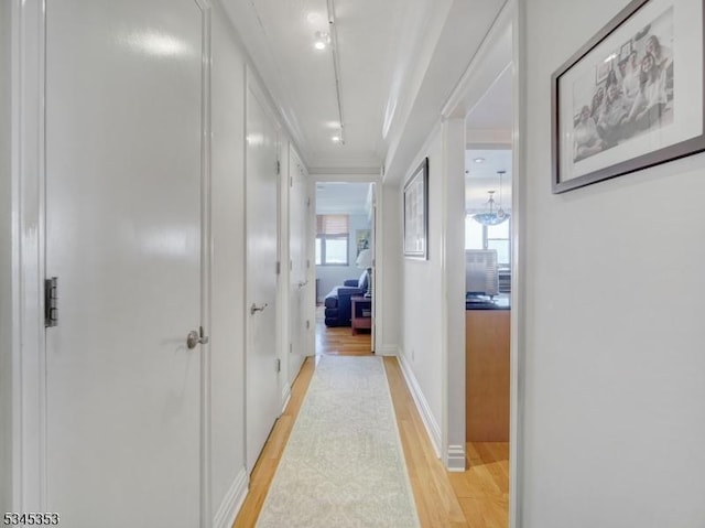 corridor featuring baseboards and light wood-style floors