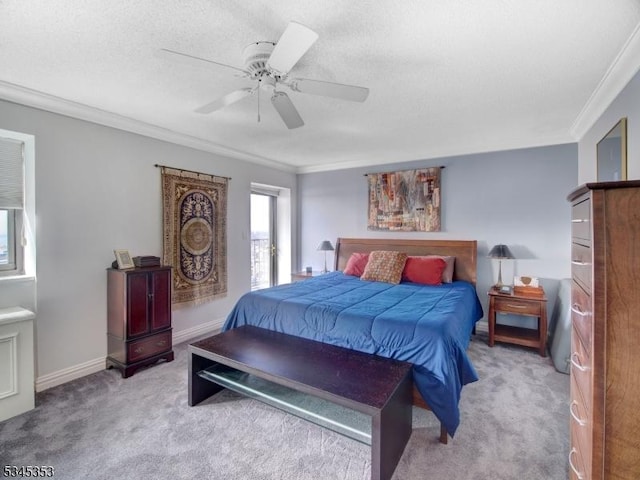 bedroom with ceiling fan, baseboards, ornamental molding, carpet floors, and a textured ceiling