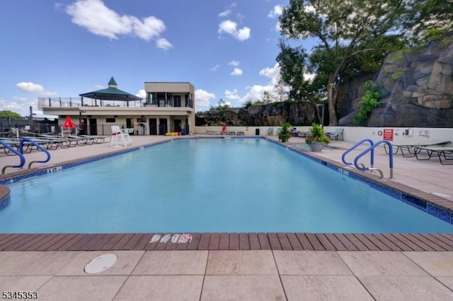community pool featuring fence and a patio area