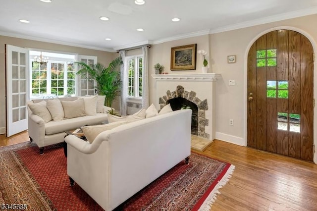110 Kenilworth Rd, Mountain Lakes Boro, NJ 07046 - living area with light wood-style flooring, ornamental molding, a fireplace with raised hearth, recessed lighting, and arched walkways
