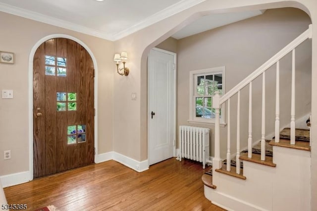 110 Kenilworth Rd, Mountain Lakes Boro, NJ 07046 - foyer entrance with radiator heating unit, arched walkways, wood finished floors, stairs, and ornamental molding