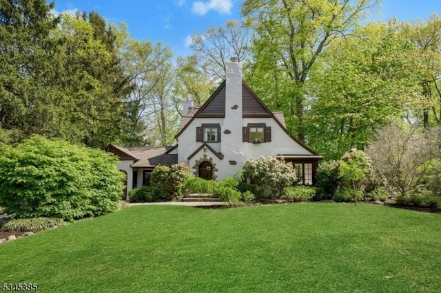110 Kenilworth Rd, Mountain Lakes Boro, NJ 07046 - view of front of house with a front lawn, a chimney, and stucco siding
