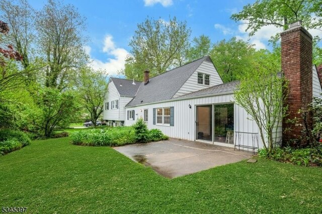 6 Ronarm Dr, Mountain Lakes Boro, NJ 07046 - rear view of property featuring a patio area, roof with shingles, a lawn, a chimney, and board and batten siding