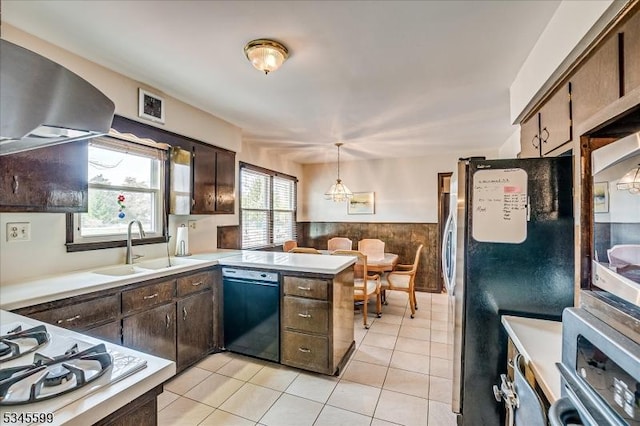 31 Riverview Ter, Hillsborough Twp, NJ 08844 - kitchen featuring a wainscoted wall, a peninsula, a sink, stainless steel appliances, and wall chimney exhaust hood