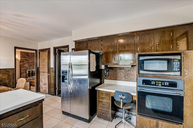 31 Riverview Ter, Hillsborough Twp, NJ 08844 - kitchen featuring dark brown cabinets, a wainscoted wall, light countertops, light tile patterned floors, and appliances with stainless steel finishes