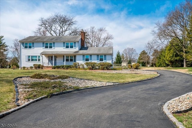 31 Riverview Ter, Hillsborough Twp, NJ 08844 - view of front of home featuring aphalt driveway, covered porch, a chimney, and a front lawn