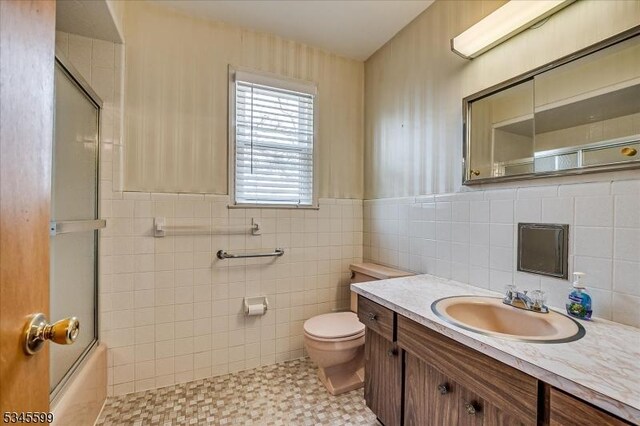 31 Riverview Ter, Hillsborough Twp, NJ 08844 - bathroom with toilet, tile walls, wainscoting, enclosed tub / shower combo, and vanity