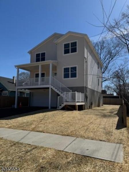 view of front of house featuring stairs, a porch, and a garage