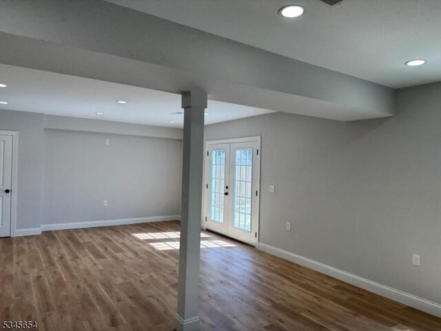 basement featuring baseboards, wood finished floors, and recessed lighting