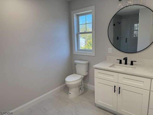 bathroom featuring marble finish floor, toilet, a stall shower, and baseboards