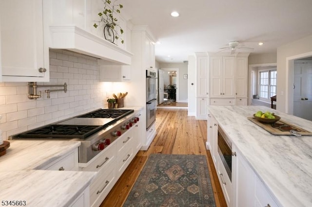 112 Pleasant Grove Rd, Washington Twp, NJ 07853 - kitchen with light wood-style flooring, stainless steel appliances, decorative backsplash, ceiling fan, and white cabinets