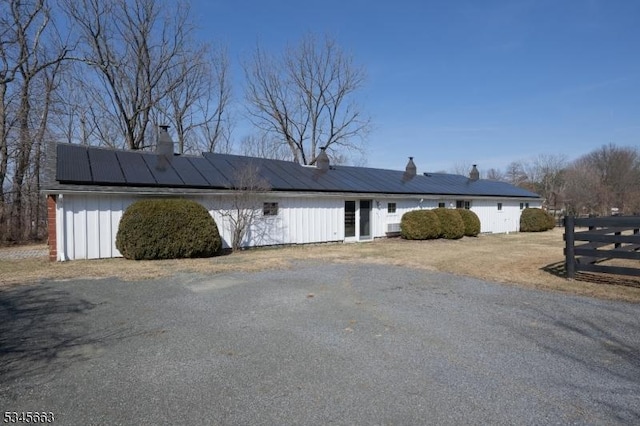 112 Pleasant Grove Rd, Washington Twp, NJ 07853 - view of front facade with roof mounted solar panels, a chimney, and fence