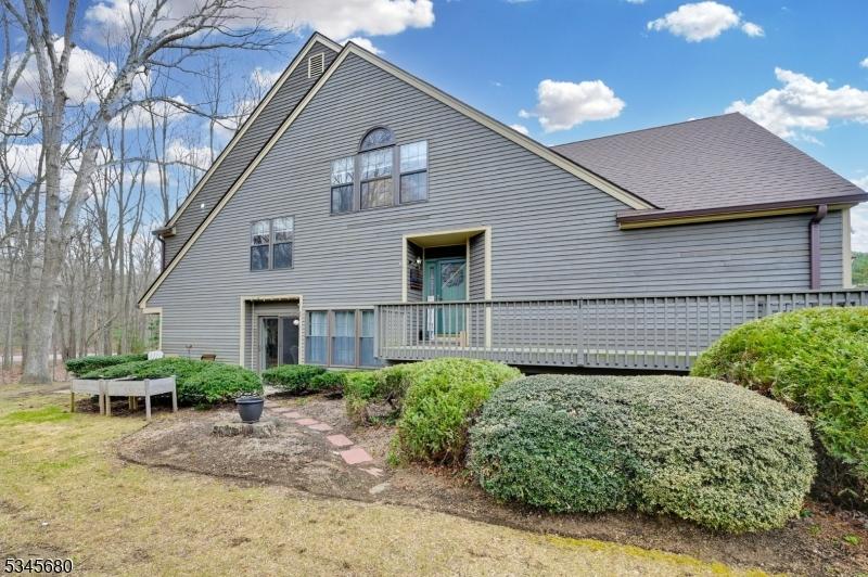 back of property featuring a wooden deck and roof with shingles