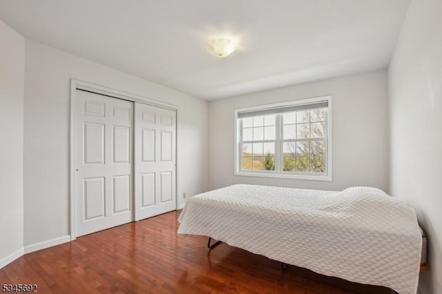bedroom featuring a closet, wood finished floors, and baseboards