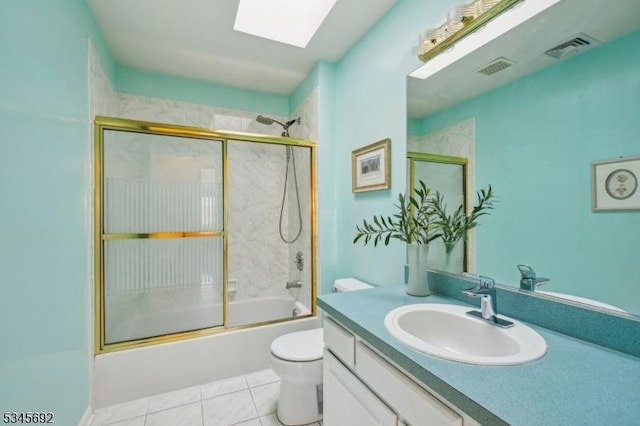 bathroom with toilet, a skylight, visible vents, and combined bath / shower with glass door