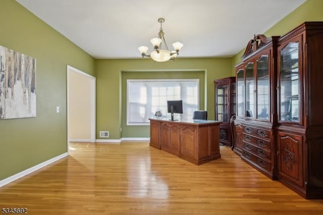 office area featuring baseboards, visible vents, a notable chandelier, and light wood-style flooring