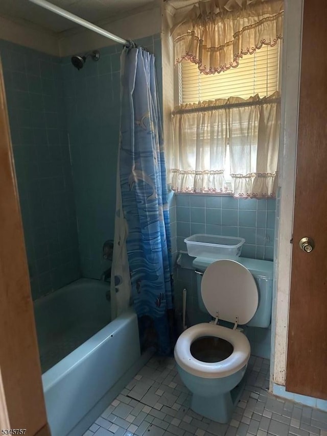 full bathroom featuring shower / bath combination with curtain, toilet, and tile walls