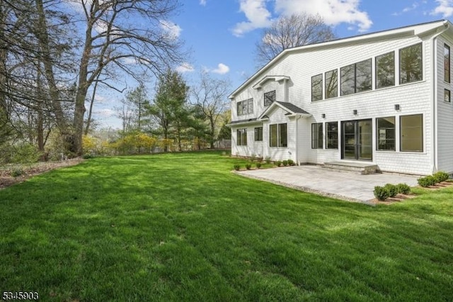 rear view of property with a yard and a patio